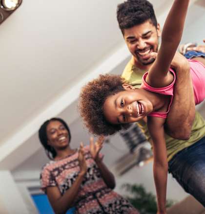 A man lifts a woman up while another woman claps.
