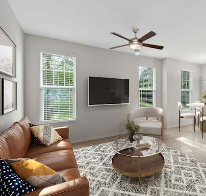 A living room with a brown leather couch and a white armchair.