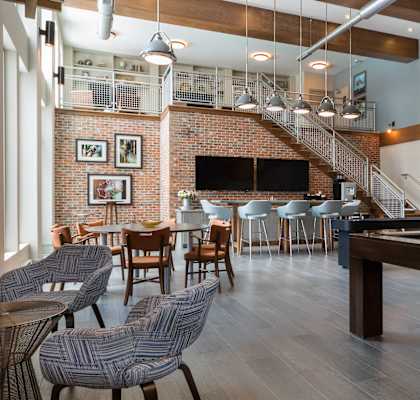 A room with a pool table and a staircase.