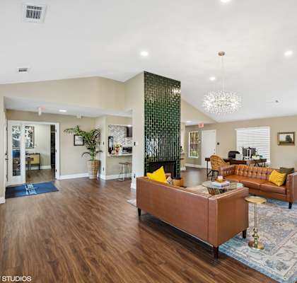 a living room with a leather couch and a fireplace at The Birches Apartment Homes, Memphis, TN