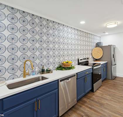 a kitchen with blue cabinets and a white counter top and a sink at The Stella in Memphis, TN