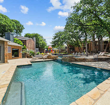 A swimming pool surrounded by a stone border.