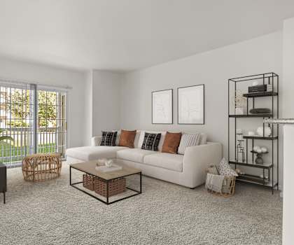 A living room with a white couch, a coffee table, and a plant.