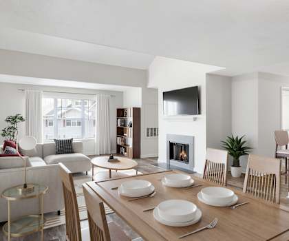 A modern dining room with a fireplace and a TV mounted on the wall.