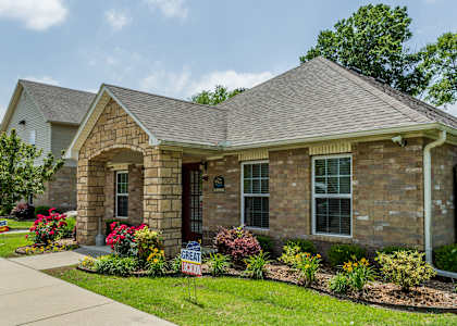a brick house with a sidewalk in front of it