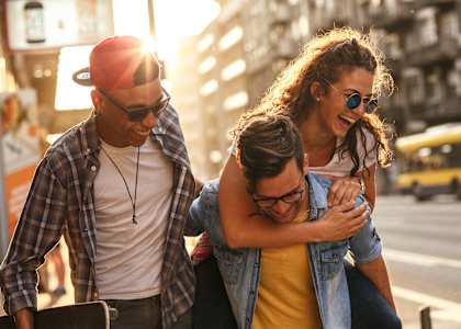 two men and a woman walking down a city street holding a girl
