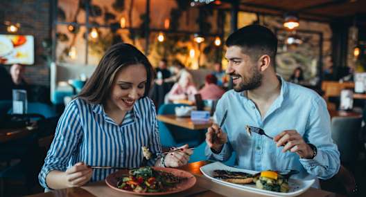 A man and a woman are enjoying a meal together in a restaurant.