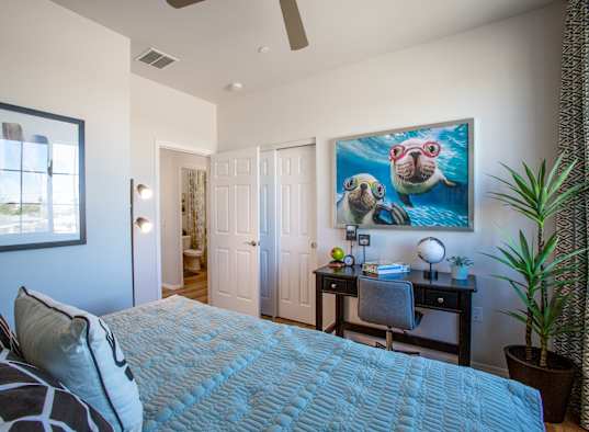 a bedroom with a large bed and a desk with a chair