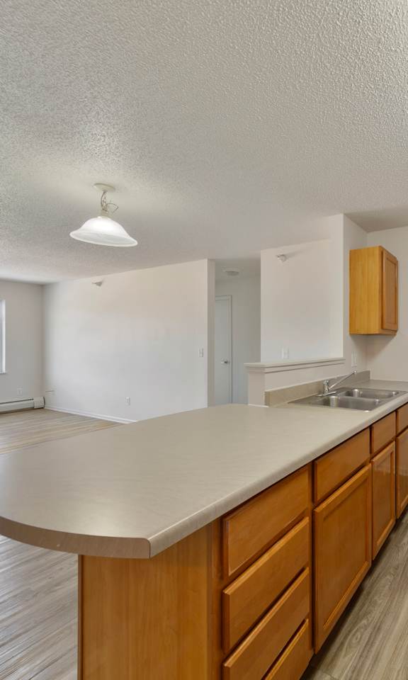 A kitchen with wooden cabinets and a white stove top oven.