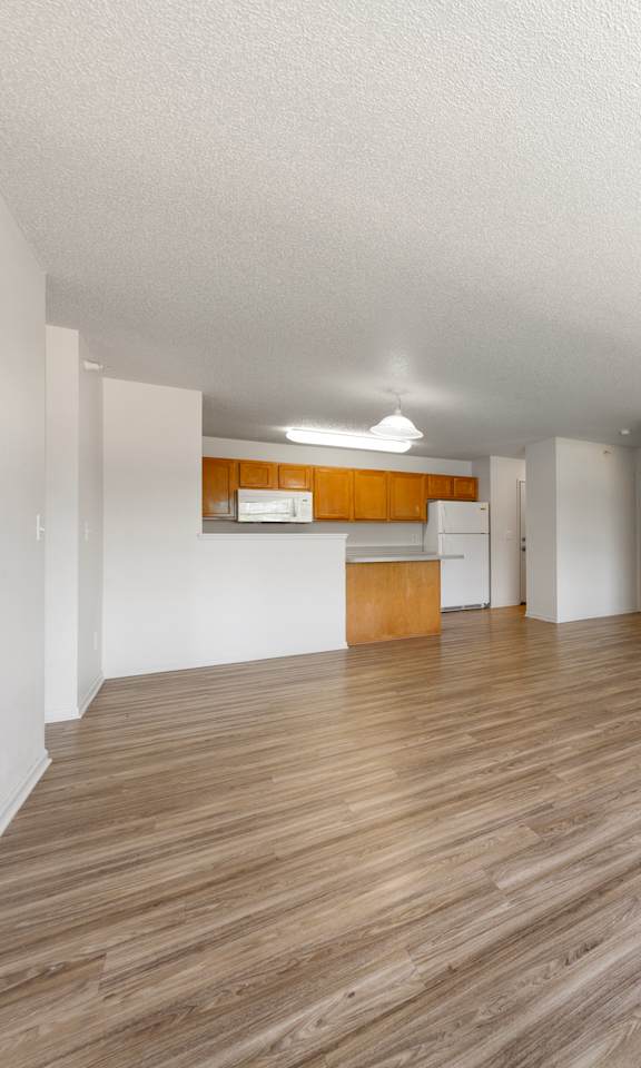 A room with wooden flooring and white walls.