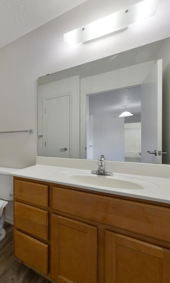A white toilet sits in a bathroom next to a white sink.