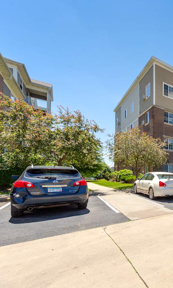 A parking lot with cars and apartment buildings in the background.