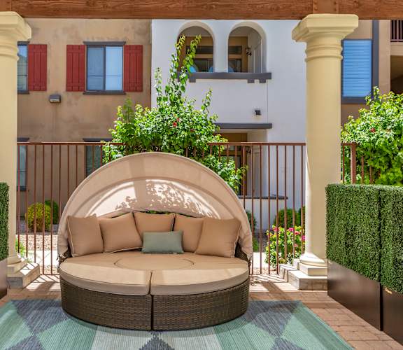 a patio with a couch and a rug in front of a building  at Trevi Apartment Homes, Chandler, Arizona