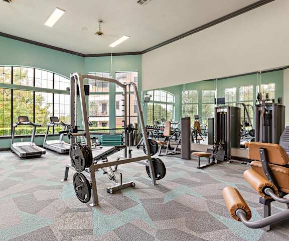 a gym with weights and other exercise equipment and windows at The Vista on Brodie, Austin, Texas
