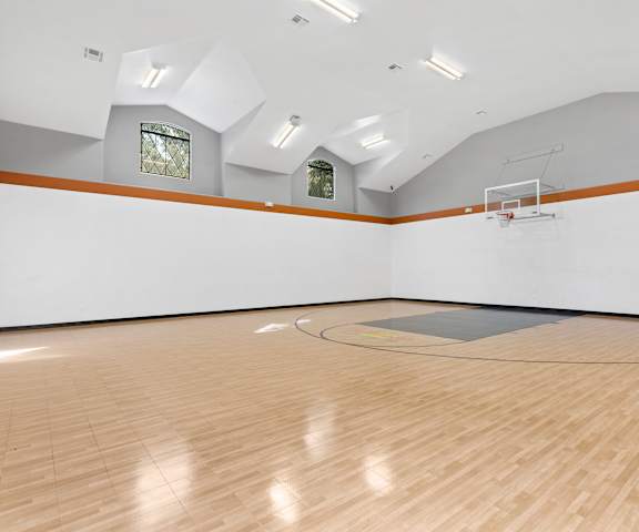 a large white room with a basketball hoop and a wood floor at The Verandah, Texas, 78726