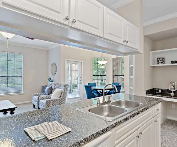 A kitchen with a granite countertop and white cabinets.