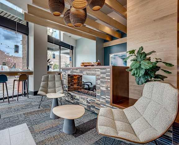 a living room with a fireplace and a bar with stools