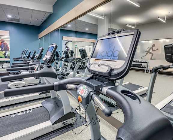 a room filled with cardio equipment and a large mirror
