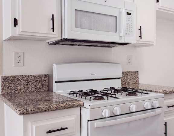 A white stove and microwave in a kitchen.