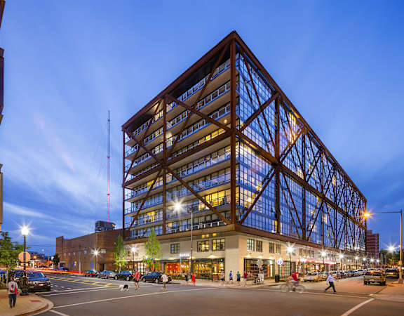 a large glass building on a city street at night