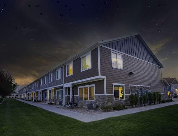 the exterior of a house at night with the lights on in the windows