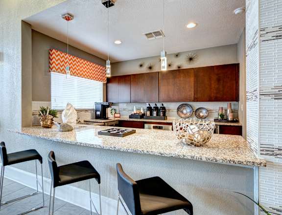 a kitchen with a granite counter top and a bar with stools