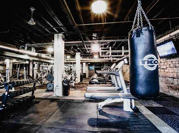 a boxing gym with a punching bag hanging from the ceiling