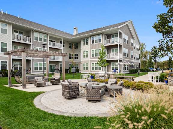 A large building with a patio and seating area in front.