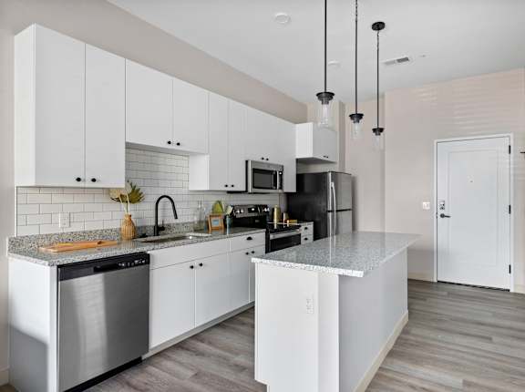 A modern kitchen with white cabinets and a central island.