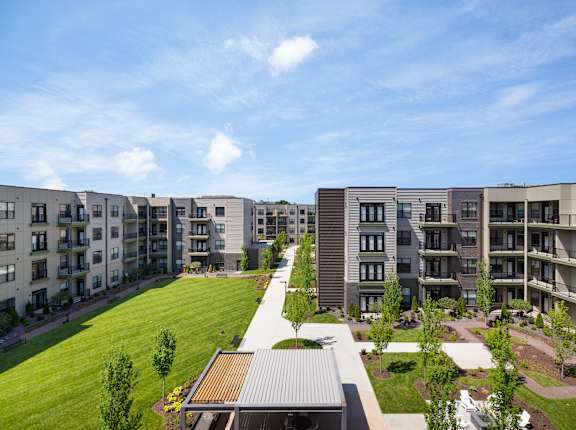 Apartment complex with a green lawn in front.