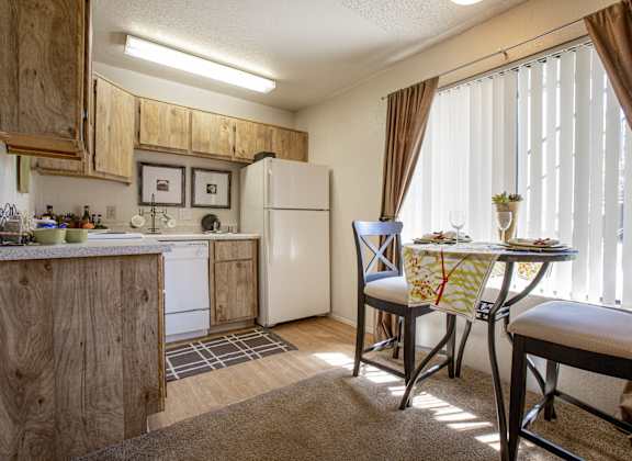 a kitchen and dining area with a table and chairs and a refrigerator