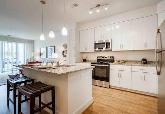 a kitchen with white cabinets and a counter top at Woodmore Grand Apartments in Bowie, MD