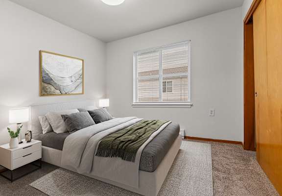 A bedroom with a bed, nightstand, and a painting on the wall.
