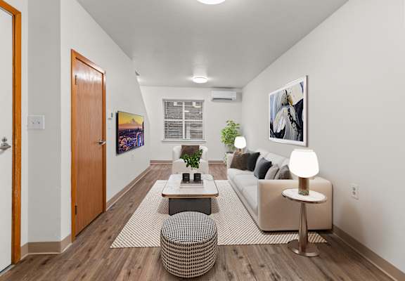 A living room with a couch, a coffee table, and a potted plant.