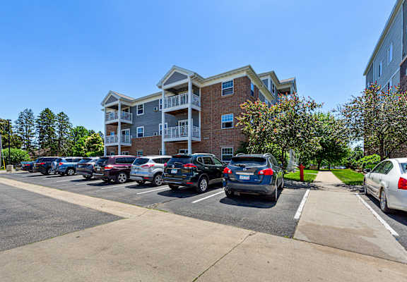A parking lot with cars and a building in the background.