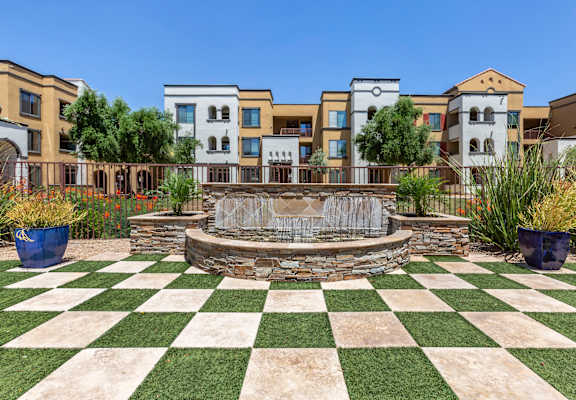 a green and white checkered lawn with a fountain in the middle of it at Trevi Apartment Homes, Arizona, 85224
