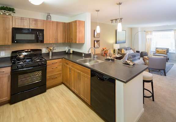a kitchen with an island and a living room with a couch at Merion Stratford Apartment Homes, Stratford