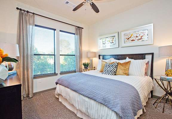 a bedroom with a large bed and a ceiling fan