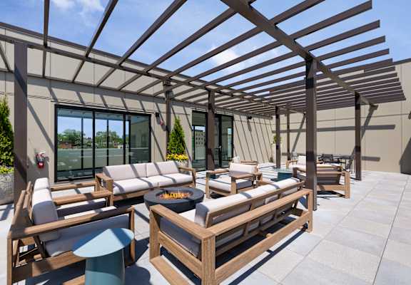 A wooden patio with a fire pit and seating area.