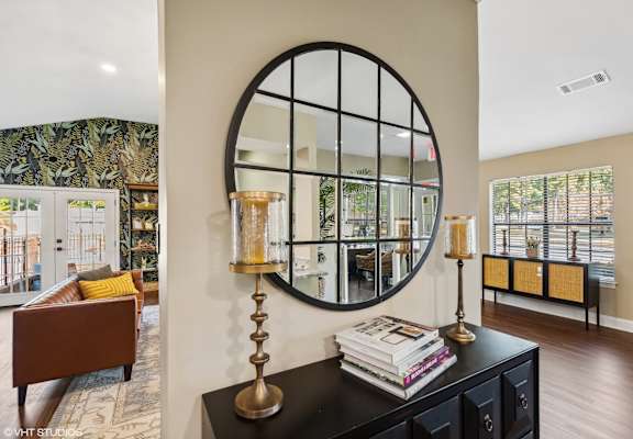a living room with a large circular mirror on the wall at The Birches Apartment Homes, Memphis, TN