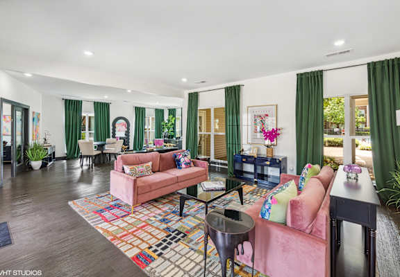 a living room with pink furniture and green curtains at The Local Apartments, Memphis, Tennessee