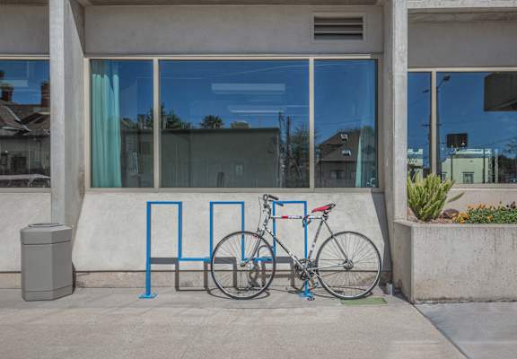 A bicycle is parked next to a blue bike rack. at Herbert Residential, Arizona 85701