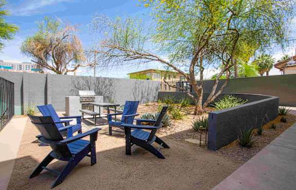 A patio with blue chairs and a table.
