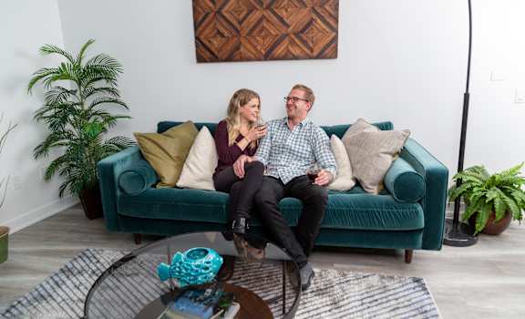 a man and a woman sitting on a couch in a living room