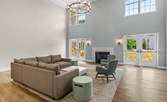 A living room with a brown couch, a green chair, and a fireplace.