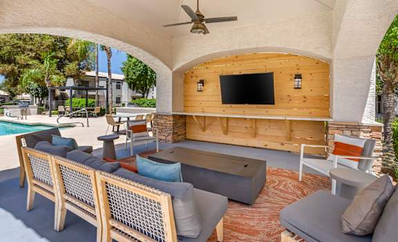 a patio with couches and chairs and a flat screen tv at Boulders at Lookout Mountain Apartment Homes, Arizona, 85022