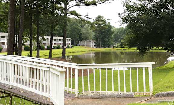 a view of a pond with a white fence around it