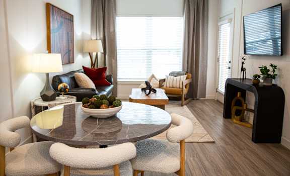 A modern dining room with a round table and chairs.