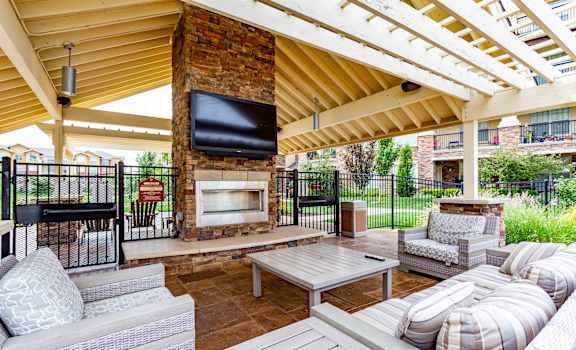 A patio with a fireplace and seating area.