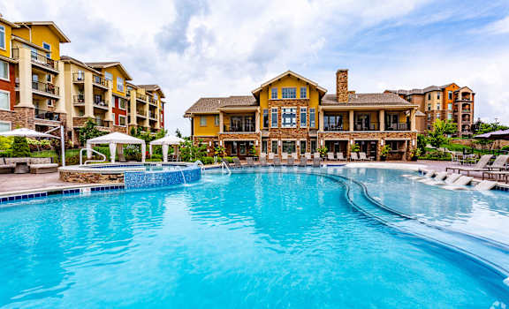 A large swimming pool in front of a resort-style building.